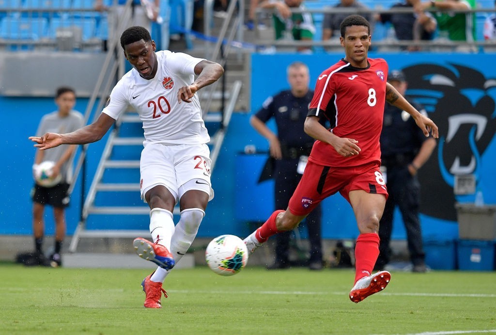 CHARLOTTE, NORTH CAROLINA - JUNE 23: Jonathan David #20 of Canada takes a shot on goal as Alejandro Portal #8 of Cuba defends during the second half of their Group A 2019 CONCACAF Gold Cup match at Bank of America Stadium on June 23, 2019, in Charlotte, North Carolina. Canada won 7-0. (Photo by Grant Halverson/Getty Images)