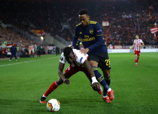 Ousseynou Ba of Olympiacos FC battles for possession with Joe Willock of Arsenal during the UEFA Europa League round of 32 first leg match between Olympiacos FC and Arsenal FC at Karaiskakis Stadium on February 20, 2020 in Piraeus, Greece.