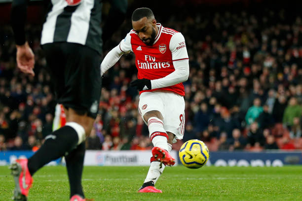 Arsenal's French striker Alexandre Lacazette shoots to score their fourth goal during the English Premier League football match between Arsenal and Newcastle United at the Emirates Stadium in London on February 16, 2020. - Arsenal won the game 4-0.