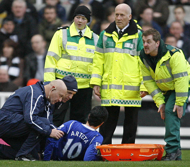 A medic (R) signals an injury to the leg of Everton's Spanish player Mikel Arteta (Below) during a Premier League football match against Newcastle at St James' Park in Newcastle, on February 22, 2009. AFP PHOTO/IAN KINGTON 