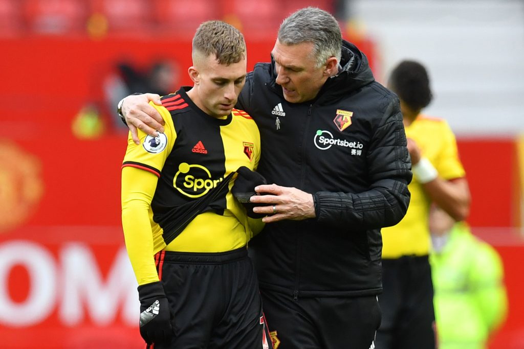 Watford's English head coach Nigel Pearson (R) puts his arm around Watford's Spanish midfielder Gerard Deulofeu (L) at the end of the English Premier League football match between Manchester United and Watford at Old Trafford in Manchester, north west England, on February 23, 2020. 