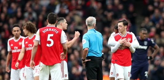 Granit Xhaka and Mesut Ozil of Arsenal speak to referee Martin Atkinson during the Premier League match between Arsenal FC and West Ham United at Emirates Stadium on March 07, 2020 in London, United Kingdom.