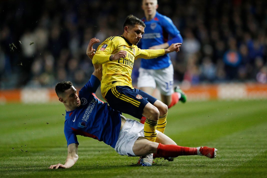 Portsmouth's English defender James Bolton (L) challenges Arsenal's Uruguayan midfielder Lucas Torreira (R) resulting in an injury for Torreira during the English FA Cup fifth round football match between Portsmouth and Arsenal at Fratton Park stadium in Portsmouth, southern England, on March 2, 2020.