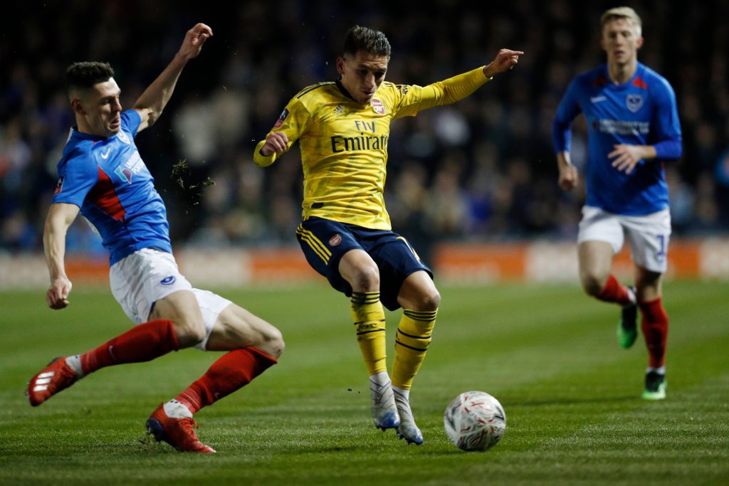 Portsmouth's English defender James Bolton (L) challenges Arsenal's Uruguayan midfielder Lucas Torreira (C) resulting in an injury for Torreira during the English FA Cup fifth round football match between Portsmouth and Arsenal at Fratton Park stadium in Portsmouth, southern England, on March 2, 2020.