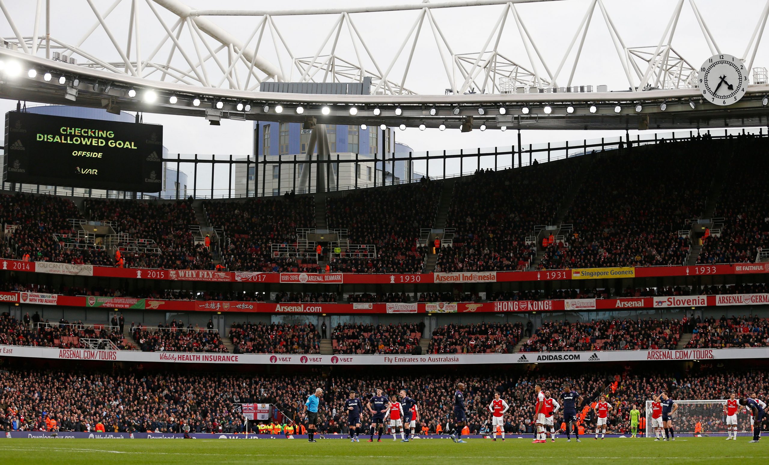 Players wait on the pitch while a VAR (Video Assistant Referee) review is conducted before awarding a goal to Arsenal during the English Premier League football match between Arsenal and West Ham at the Emirates Stadium in London on March 7, 2020.