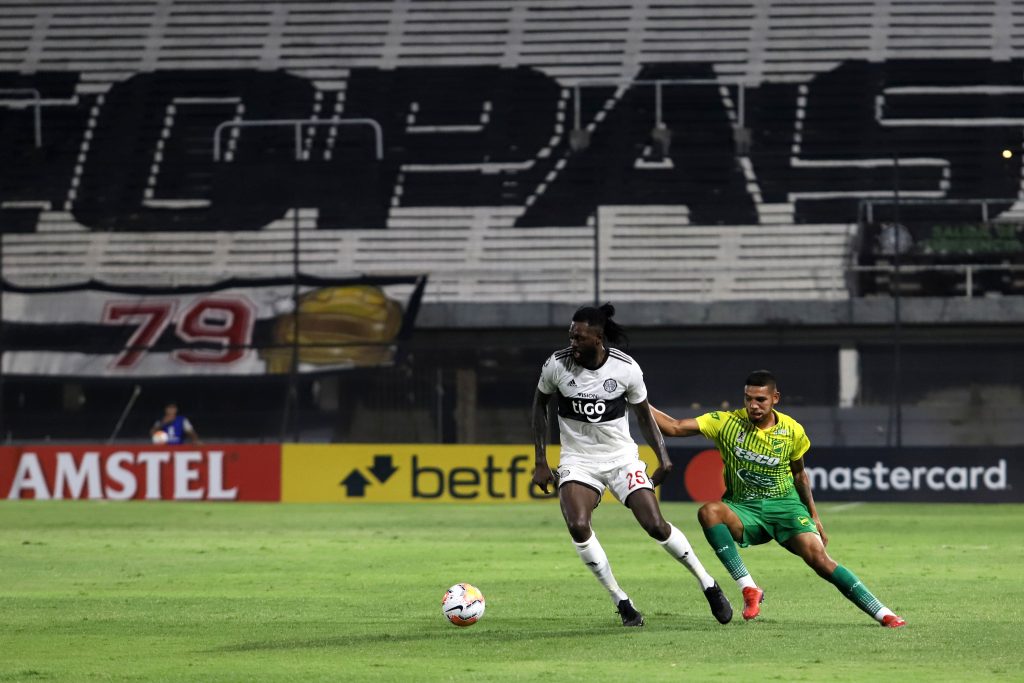 ASUNCION, PARAGUAY - MARCH 11: Emmanuel Adebayor of Olimpia and Hector Martinez of Defensa y Justicia fight for the ball during a match between Olimpia and Defensa y Justicia as part of Copa CONMEBOL Libertadores at Tigo Manuel Ferreira Stadium on March 11, 2020, in Asuncion, Paraguay. (Photo by Luis Vera/Getty Images)