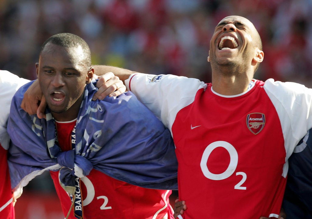 Arsenal's Invincibles LONDON, UNITED KINGDOM: Arsenal's Patrick Vieira (L) and Thierry Henry celebrate after winning the Premiership title and defeating Leicsester City 15 May, 2004 at Highbury in London. Arsenal defeated Leicester City 2-1 and finish the season undefeated. AFP PHOTO/JIM WATSON (Photo credit should read JIM WATSON/AFP via Getty Images)
