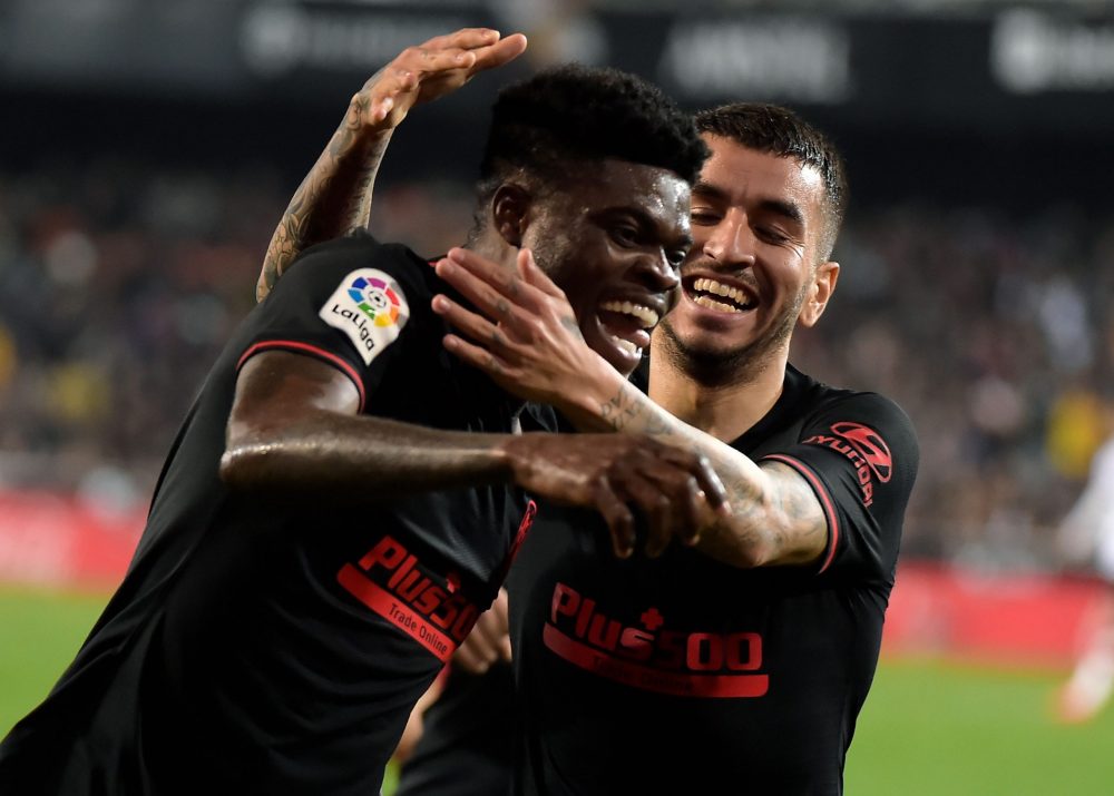 Atletico Madrid's Ghanaian midfielder Thomas Partey (L) celebrates with Atletico Madrid's Argentine forward Angel Correa after scoring during the Spanish league football match between Valencia CF and Club Atletico de Madrid at the Mestalla stadium in Valencia on February 14, 2020. (Photo by JOSE JORDAN / AFP)
