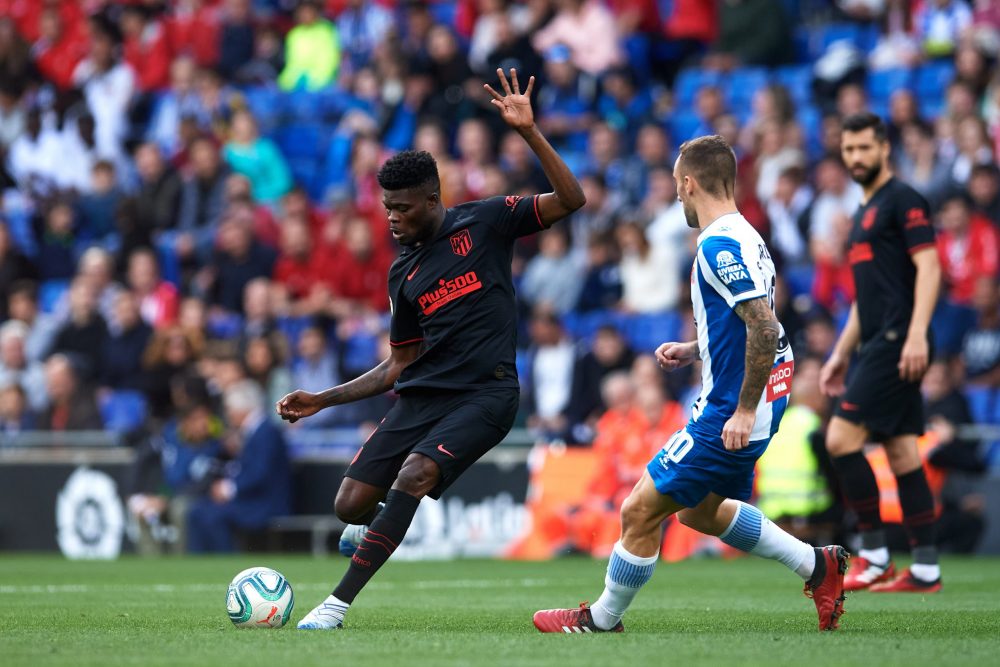 BARCELONA, SPAIN - MARCH 01: Thomas Partey of Atletico de Madrid plays the ball under pressure from Sergi Darder of RCD Espanyol during the Liga match between RCD Espanyol and Club Atletico de Madrid at RCDE Stadium on March 01, 2020 in Barcelona, Spain. (Photo by Alex Caparros/Getty Images)