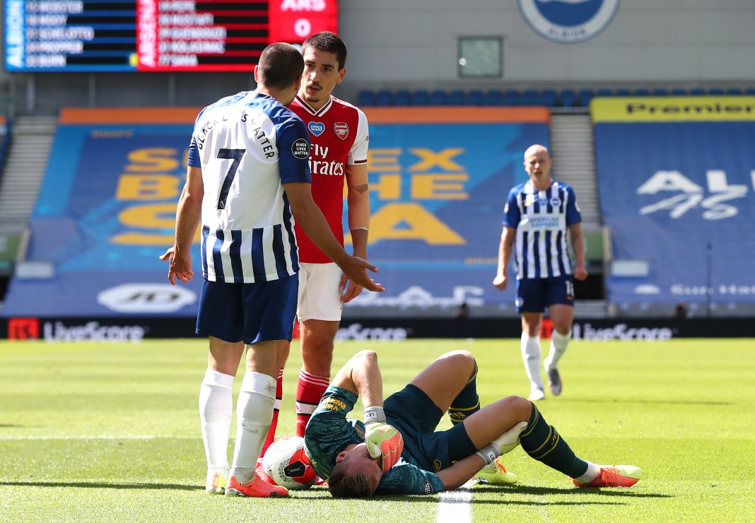 BRIGHTON, ENGLAND - JUNE 20: Bernd Leno of Arsenal goes down injured and in pain as Neal Maupay of Brighton and Hove Albion argues with Hector Bellerin of Arsenal during the Premier League match between Brighton & Hove Albion and Arsenal FC at American Express Community Stadium on June 20, 2020 in Brighton, England. Football Stadiums around Europe remain empty due to the Coronavirus Pandemic as Government social distancing laws prohibit fans inside venues resulting in all fixtures being played behind closed doors. (Photo by Gareth Fuller/Pool via Getty Images)