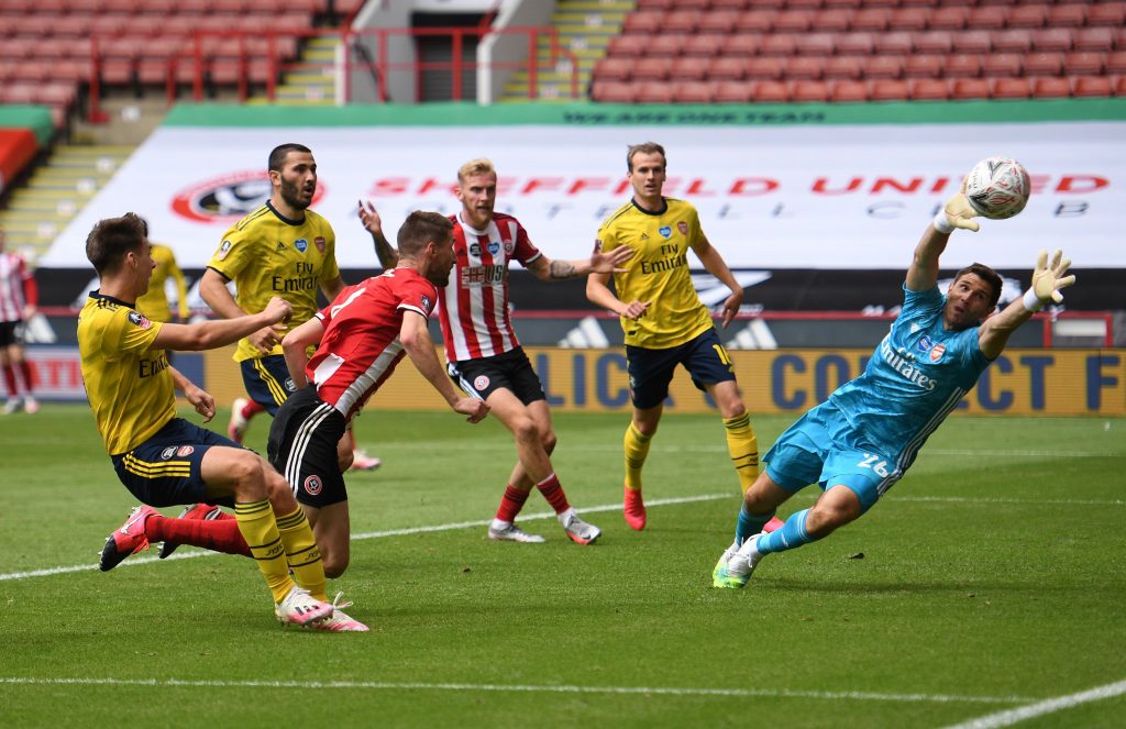 Sheffield United's English defender Chris Basham (3L) heads the ball wide past Arsenal's Argentinian goalkeeper Emiliano Martinez (R) during the English FA Cup quarter-final football match between Sheffield United and Arsenal at Bramall Lane in Sheffield, northern England on June 28, 2020. (Photo by Oli SCARFF / POOL / AFP) / RESTRICTED TO EDITORIAL USE. No use with unauthorized audio, video, data, fixture lists, club/league logos or 'live' services. Online in-match use limited to 120 images. An additional 40 images may be used in extra time. No video emulation. Social media in-match use limited to 120 images. An additional 40 images may be used in extra time. No use in betting publications, games or single club/league/player publications. / (Photo by OLI SCARFF/POOL/AFP via Getty Images)