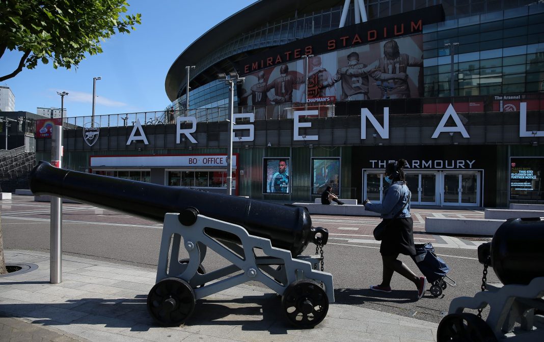 A person wearing PPE (personal protective equipment), including a face mask as a precautionary measure against COVID-19 walks outside the Emirates stadium, the home ground of English Premier League football team Arsenal, in north London on May 19, 2020, as training resumes for the first time since the Premier League was halted due to the COVID-19 pandemic. - Premier League clubs will return to training in small groups from Tuesday after the latest stage of 