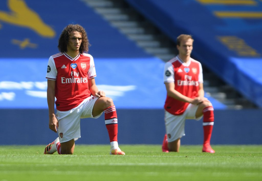 Arsenal's French midfielder Matteo Guendouzi (L) takes a knee to show support for the Black Lives Matter movement and as a protest against racism ahead of the English Premier League football match between Brighton and Hove Albion and Arsenal at the American Express Community Stadium in Brighton, southern England on June 20, 2020. (Photo by Mike Hewitt / POOL / AFP)