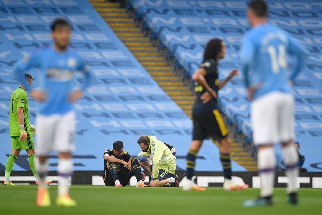 Arsenal's Spanish defender Pablo Mari (C) sits on the pitch after picking up an injury during the English Premier League football match between Manchester City and Arsenal at the Etihad Stadium in Manchester, north west England, on June 17, 2020. - The Premier League makes its eagerly anticipated return today after 100 days in lockdown but behind closed doors due to coronavirus restrictions. (Photo by PETER POWELL / POOL / AFP)