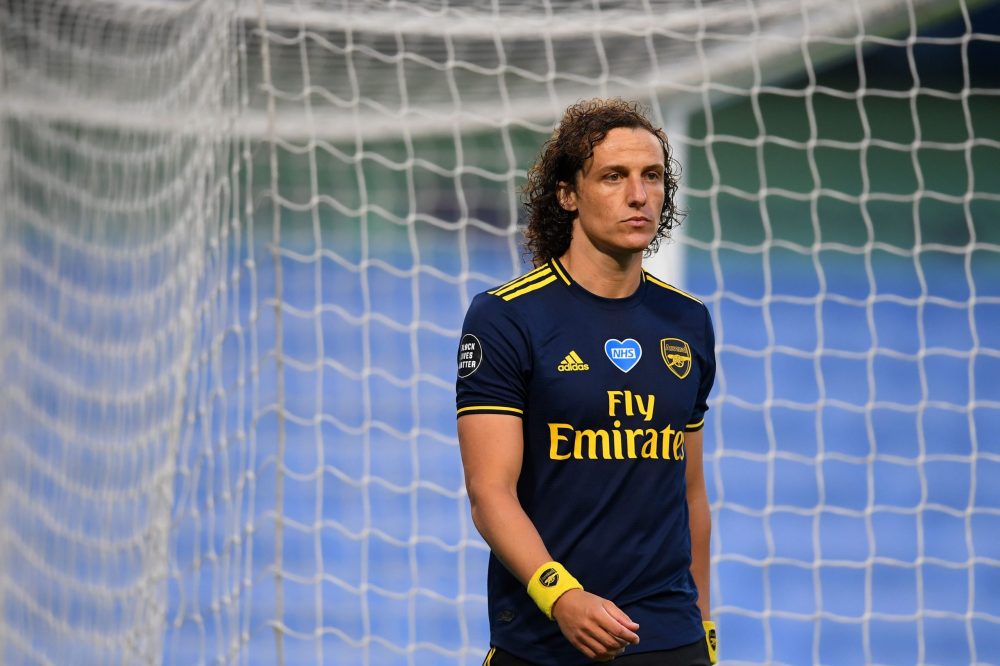 The Logo of Britain's NHS (National Health Service) is seen on th eshirt of Arsenal's Brazilian defender David Luiz as he leaves the pitch after receiving a red card during the English Premier League football match between Manchester City and Arsenal at the Etihad Stadium in Manchester, north west England, on June 17, 2020. - The Premier League makes its eagerly anticipated return today after 100 days in lockdown but behind closed doors due to coronavirus restrictions. (Photo by LAURENCE GRIFFITHS / POOL / AFP) / RESTRICTED TO EDITORIAL USE. No use with unauthorized audio, video, data, fixture lists, club/league logos or 'live' services. Online in-match use limited to 120 images. An additional 40 images may be used in extra time. No video emulation. Social media in-match use limited to 120 images. An additional 40 images may be used in extra time. No use in betting publications, games or single club/league/player publications. / (Photo by LAURENCE GRIFFITHS/POOL/AFP via Getty Images)