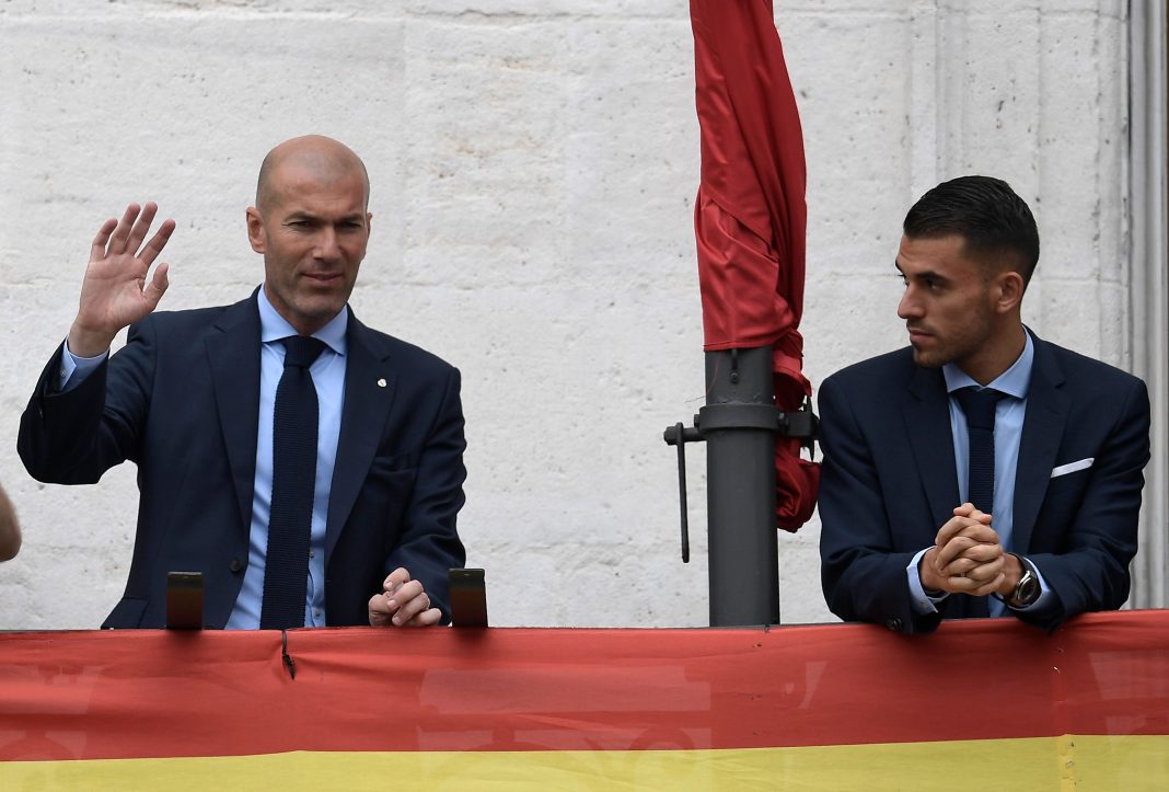 Real Madrid's French coach Zinedine Zidane (L) and Real Madrid's Spanish midfielder Daniel Ceballos greet supporters from the balcony of the headquarters of the regional government of Madrid at the Puerta del Sol square in Madrid on May 27, 2018 as they celebrate their third Champions League title in a row in Kiev. (Photo by OSCAR DEL POZO / AFP)