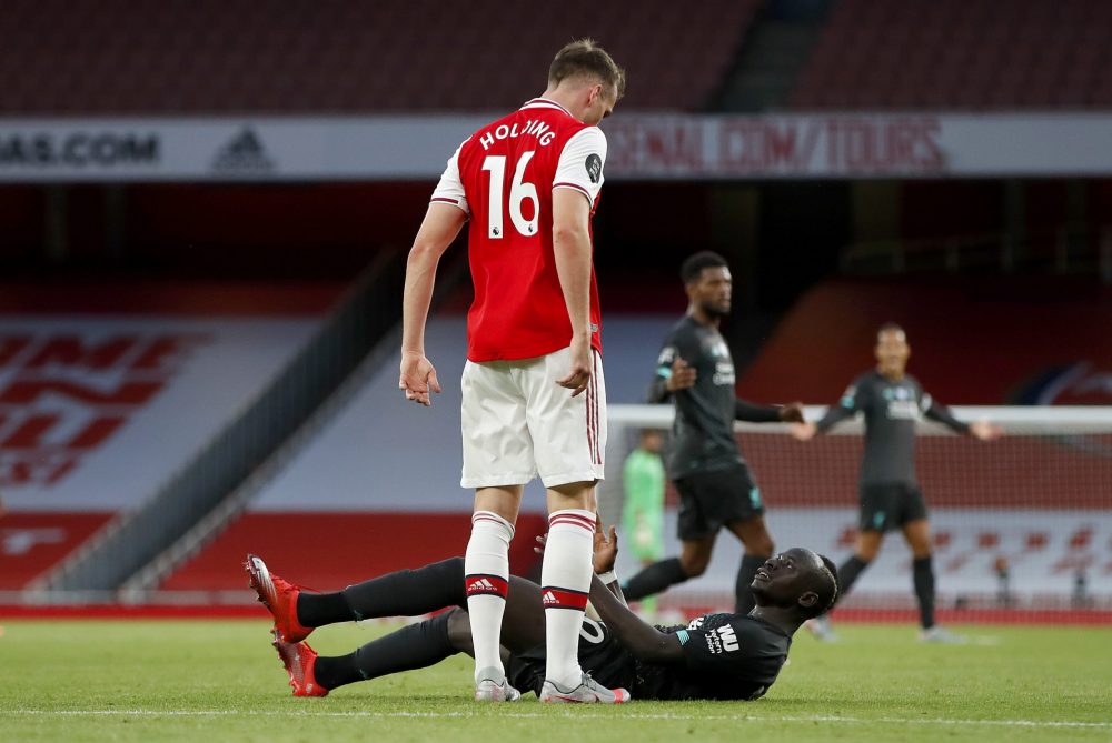 LONDON, ENGLAND - JULY 15: Sadio Mane of Liverpool clashes with Rob Holding of Arsenal during the Premier League match between Arsenal FC and Liverpool FC at Emirates Stadium on July 15, 2020 in London, England. Football Stadiums around Europe remain empty due to the Coronavirus Pandemic as Government social distancing laws prohibit fans inside venues resulting in all fixtures being played behind closed doors. (Photo by Paul Childs/Pool via Getty Images)