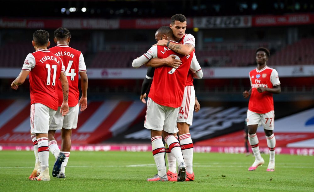 LONDON, ENGLAND - JULY 15: Alexandre Lacazette of Arsenal celebrates with teammates after scoring his sides first goal during the Premier League match between Arsenal FC and Liverpool FC at Emirates Stadium on July 15, 2020 in London, England. Football Stadiums around Europe remain empty due to the Coronavirus Pandemic as Government social distancing laws prohibit fans inside venues resulting in all fixtures being played behind closed doors. (Photo by Shaun Botterill/Getty Images)