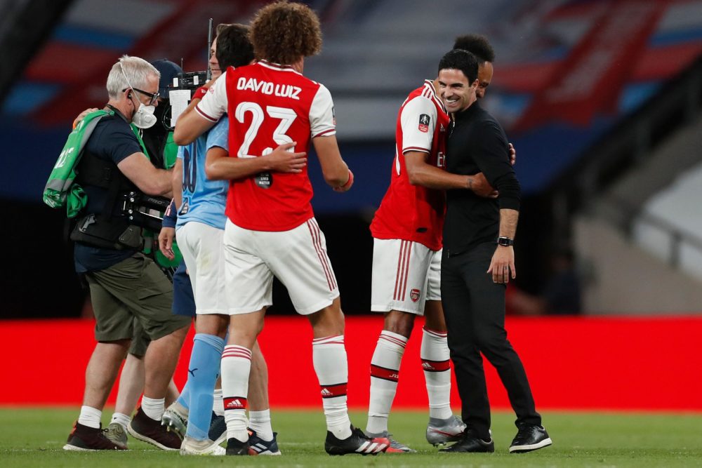 Arsenal's Spanish head coach Mikel Arteta (R) embraces Arsenal's Gabonese striker Pierre-Emerick Aubameyang (2R) at the end of the English FA Cup semi-final football match between Arsenal and Manchester City at Wembley Stadium in London, on July 18, 2020. (Photo by MATTHEW CHILDS / POOL / AFP)