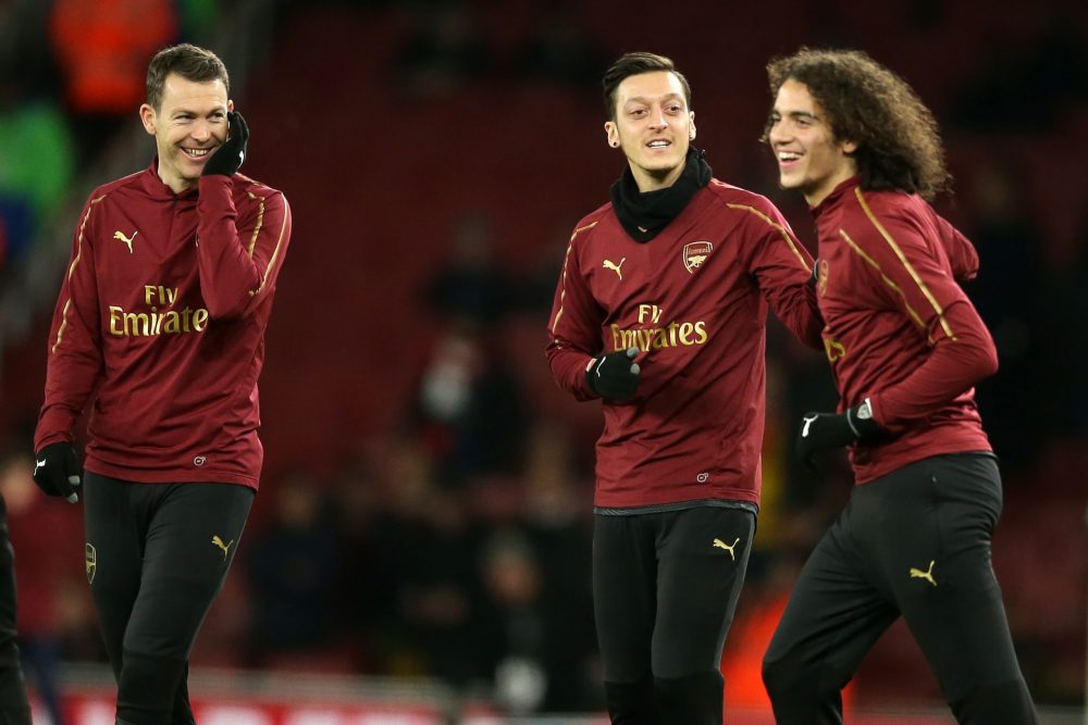 Arsenal's Swiss defender Stephan Lichtsteiner (L), Arsenal's German midfielder Mesut Ozil (C) and Arsenal's French midfielder Matteo Guendouzi (R) warm up ahead of the English FA Cup fourth round football match between Arsenal and Manchester United at the Emirates Stadium in London on January 25, 2019. (Photo by Daniel LEAL-OLIVAS / AFP)
