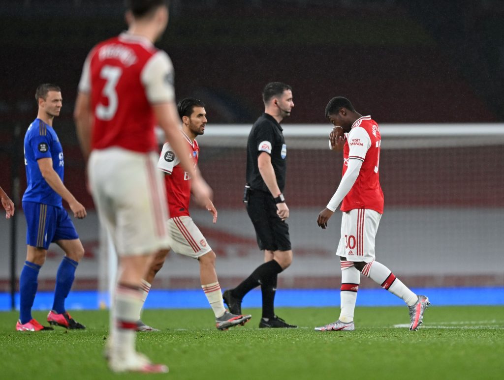 Arsenal's English striker Eddie Nketiah (R) walks off the pitch past Referee Chris Kavanagh (2nd R) after receiving a red card during the English Premier League football match between Arsenal and Leicester City at the Emirates Stadium in London on July 7, 2020. (Photo by Shaun Botterill / POOL / AFP) / RESTRICTED TO EDITORIAL USE. No use with unauthorized audio, video, data, fixture lists, club/league logos or 'live' services. Online in-match use limited to 120 images. An additional 40 images may be used in extra time. No video emulation. Social media in-match use limited to 120 images. An additional 40 images may be used in extra time. No use in betting publications, games or single club/league/player publications. / (Photo by SHAUN BOTTERILL/POOL/AFP via Getty Images)