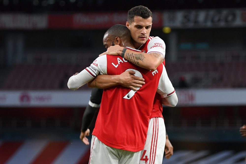 Arsenal's French striker Alexandre Lacazette (L) celebrates with Arsenal's Swiss midfielder Granit Xhaka (R) after scoring their first goal during the English Premier League football match between Arsenal and Liverpool at the Emirates Stadium in London on July 15, 2020. (Photo by Shaun Botterill / POOL / AFP) 