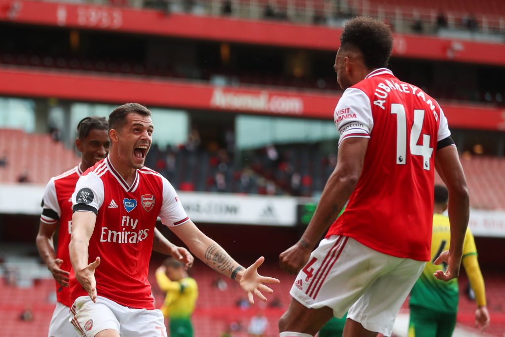Arsenal's Swiss midfielder Granit Xhaka celebrates with Arsenal's Gabonese striker Pierre-Emerick Aubameyang (R) after scoring a goal during the English Premier League football match between Arsenal and Norwich City at the Emirates Stadium in London on July 1, 2020. (Photo by MIKE EGERTON / POOL / AFP) / RESTRICTED TO EDITORIAL USE. No use with unauthorized audio, video, data, fixture lists, club/league logos or 'live' services. Online in-match use limited to 120 images. An additional 40 images may be used in extra time. No video emulation. Social media in-match use limited to 120 images. An additional 40 images may be used in extra time. No use in betting publications, games or single club/league/player publications. / (Photo by MIKE EGERTON/POOL/AFP via Getty Images)