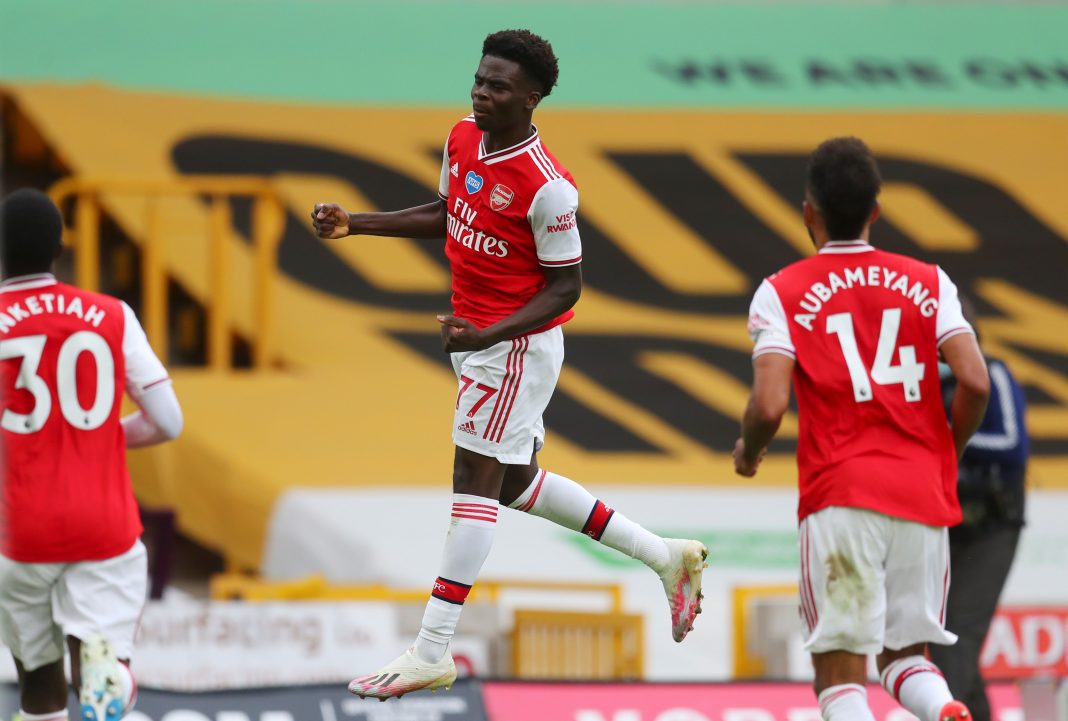 Arsenal's English striker Bukayo Saka celebrates scoring the opening goal during the English Premier League football match between Wolverhampton Wanderers and Arsenal at the Molineux stadium in Wolverhampton, central England on July 4, 2020. (Photo by Catherine Ivill / POOL / AFP) / RESTRICTED TO EDITORIAL USE. No use with unauthorized audio, video, data, fixture lists, club/league logos or 'live' services. Online in-match use limited to 120 images. An additional 40 images may be used in extra time. No video emulation. Social media in-match use limited to 120 images. An additional 40 images may be used in extra time. No use in betting publications, games or single club/league/player publications. / (Photo by CATHERINE IVILL/POOL/AFP via Getty Images)