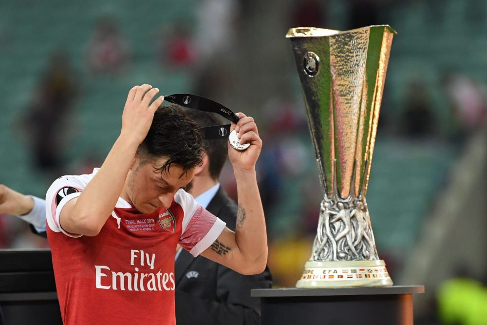 How much will Arsenal earn from the Europa League this season? Arsenal's German midfielder Mesut Ozil puts on his medal as he walks past the trophy after losing the UEFA Europa League final football match between Chelsea FC and Arsenal FC at the Baku Olympic Stadium in Baku, Azerbaijian, on May 29, 2019. (Photo by Kirill KUDRYAVTSEV / AFP) 