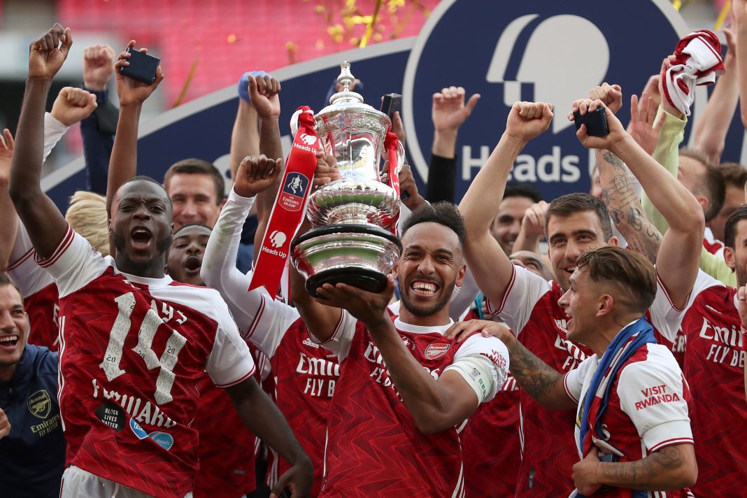 Arsenal's Gabonese striker Pierre-Emerick Aubameyang holds the winner's trophy as the team celebrates victory after the English FA Cup final football match between Arsenal and Chelsea at Wembley Stadium in London, on August 1, 2020. - Arsenal won the match 2-1. (Photo by Catherine Ivill / POOL / AFP)