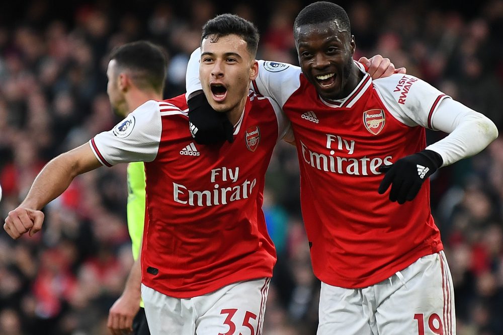 Arsenal's Brazilian striker Gabriel Martinelli (C) celebrates scoring the opening goal with Arsenal's French-born Ivorian midfielder Nicolas Pepe (R) during the English Premier League football match between Arsenal and Sheffield United at the Emirates Stadium in London on January 18, 2020. (Photo by DANIEL LEAL-OLIVAS / AFP)