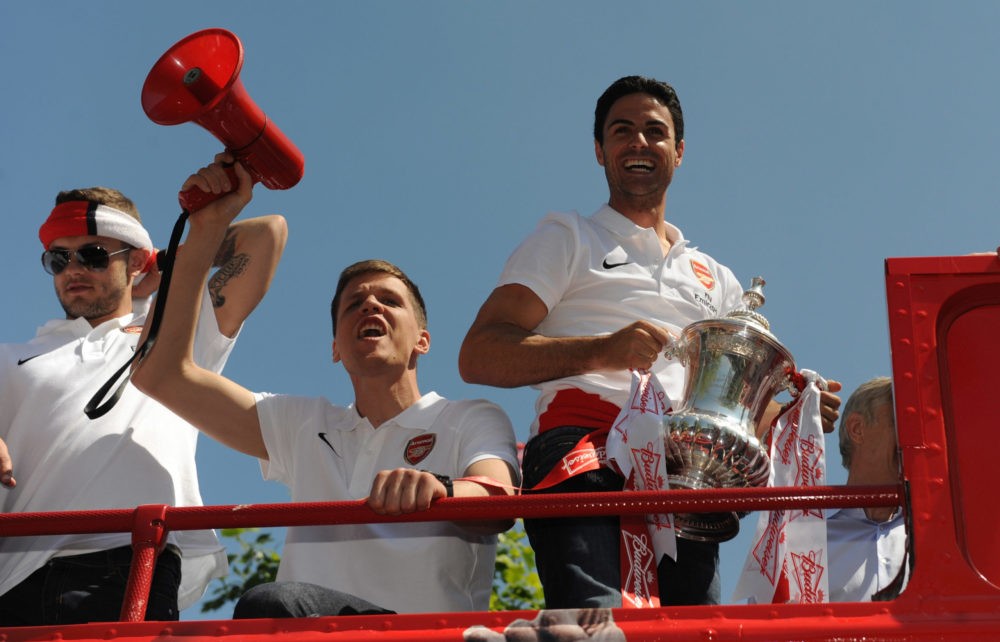 LONDON, ENGLAND - MAY 18: Jack Wilshere, Wojech Szczesny and Mikel Arteta of Arsenal FC celebrates with the FA Cup during the Arsenal FA Cup Victory Parade in Islington, London on May 18, 2014 in London, England. (Photo by Steve Bardens/Getty Images)