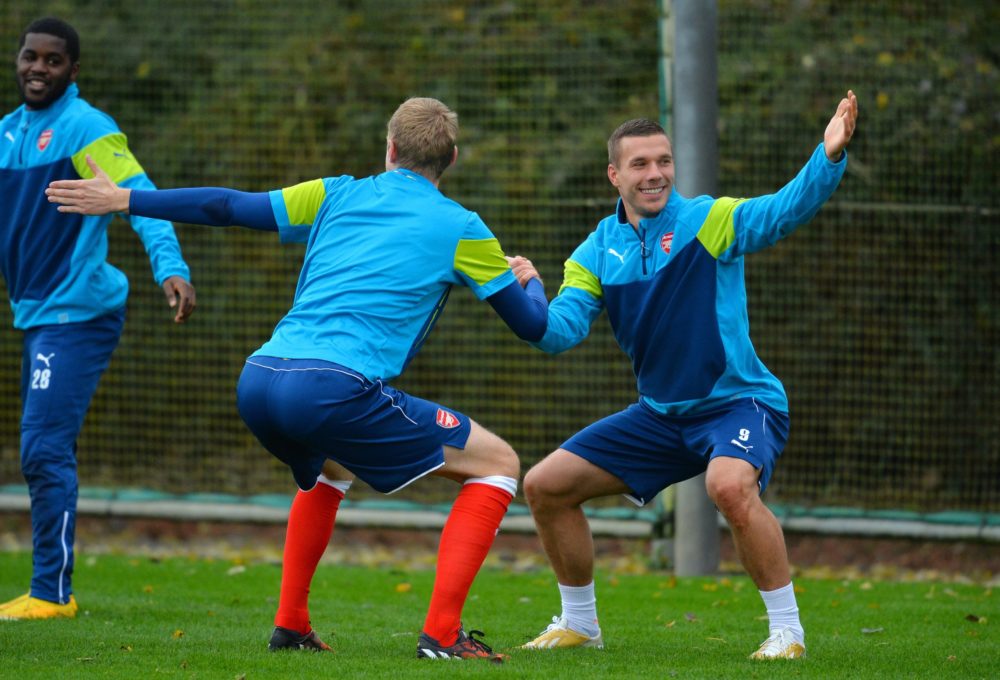 Arsenal's German defender Per Mertesacker (L) and German striker Lukas Podolski (R) attend a training session at the London Colney, North London, on November 3, 2014, on the eve of the UEFA Champions League Group D football match between Arsenal and Anderlecht. AFP PHOTO/GLYN KIRK