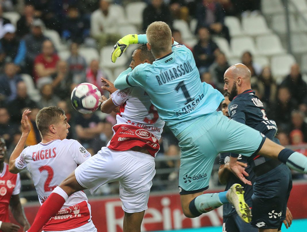 Reims' Moroccoan defender Yunis Abdedlhamid (L) vies with Dijon's Iceland goalkeeper Runar Alex Runarsson (R) during the French L1 football match between Reims and Dijon on September 22, 2018 at the Auguste Delaune Stadium in Reims. (Photo by FRANCOIS NASCIMBENI / AFP)