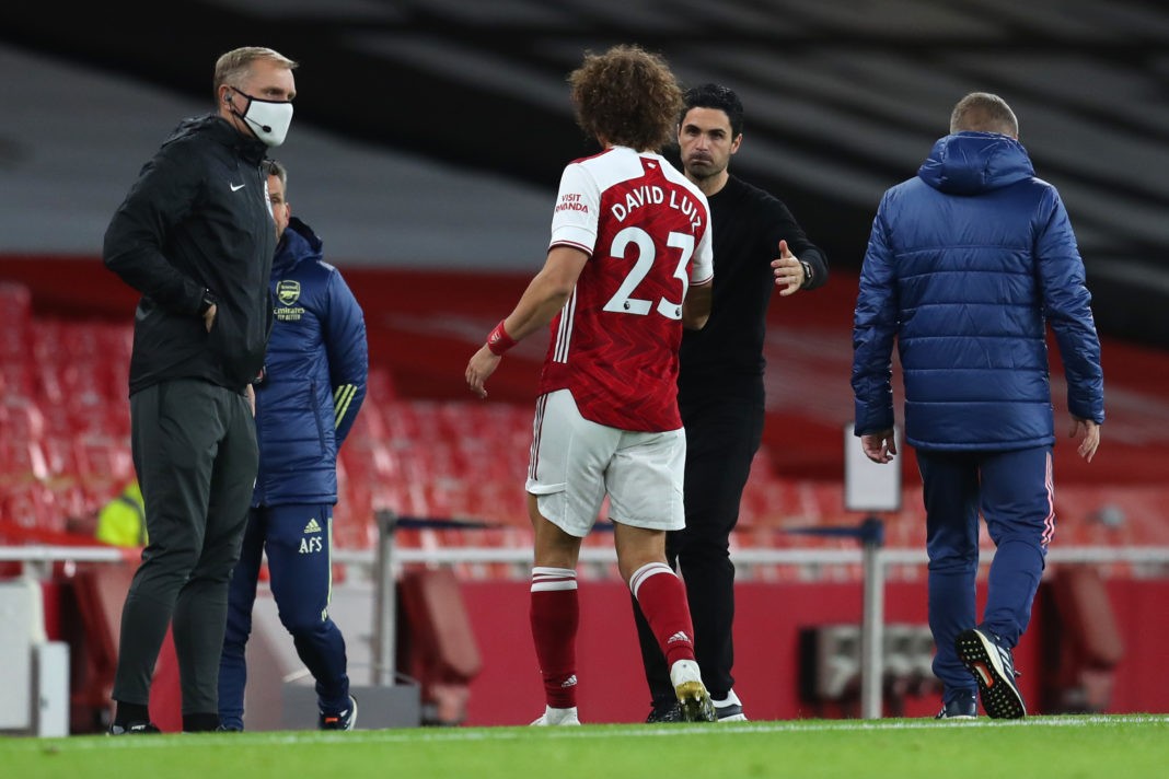 LONDON, ENGLAND: David Luiz of Arsenal is embraced by Mikel Arteta, Manager of Arsenal as he is substituted off following an injury during the Premier League match between Arsenal and Leicester City at Emirates Stadium on October 25, 2020. (Photo by Catherine Ivill/Getty Images)