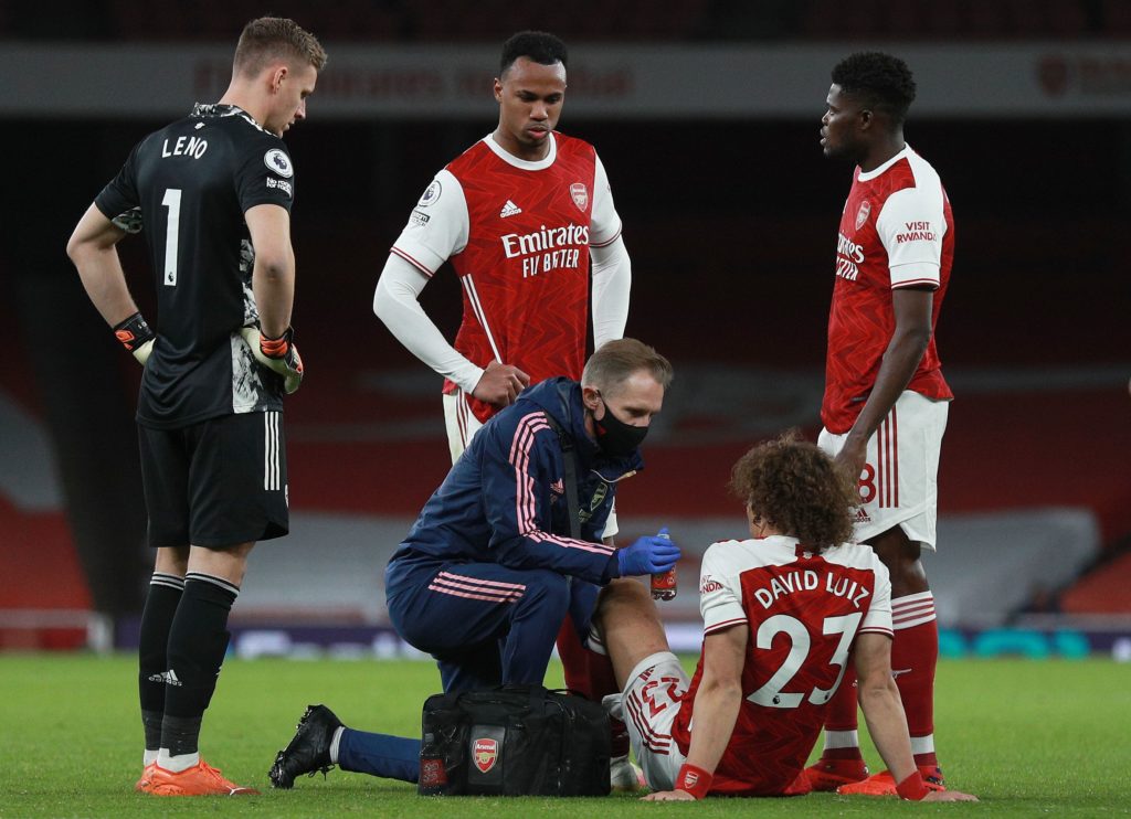 Arsenal's Brazilian defender David Luiz (2R) receives medical treatment before leaving the pitch injured during the English Premier League football match between Arsenal and Leicester City at the Emirates Stadium in London on October 25, 2020. (Photo by Ian Walton / POOL / AFP) / RESTRICTED TO EDITORIAL USE. No use with unauthorized audio, video, data, fixture lists, club/league logos or 'live' services. Online in-match use limited to 120 images. An additional 40 images may be used in extra time. No video emulation. Social media in-match use limited to 120 images. An additional 40 images may be used in extra time. No use in betting publications, games or single club/league/player publications. / (Photo by IAN WALTON/POOL/AFP via Getty Images)