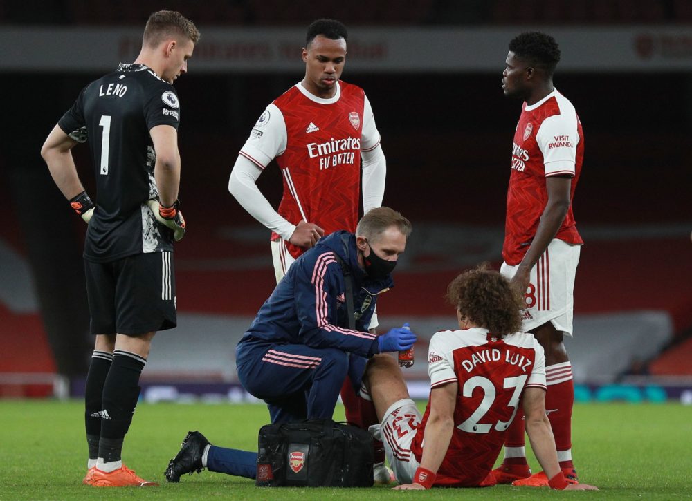 Arsenal's Brazilian defender David Luiz (2R) receives medical treatment before leaving the pitch injured during the English Premier League football match between Arsenal and Leicester City at the Emirates Stadium in London on October 25, 2020. (Photo by Ian Walton / POOL / AFP)