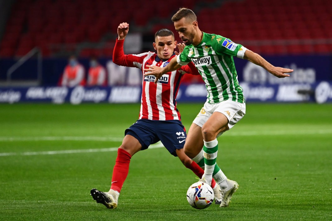 Atletico Madrid's Uruguayan midfielder Lucas Torreira (L) vies with Real Betis' Spanish midfielder Sergio Canales during the Spanish League football match between Atletico Madrid and Real Betis at the Wanda Metropolitan stadium in Madrid on October 24, 2020. (Photo by GABRIEL BOUYS/AFP via Getty Images)