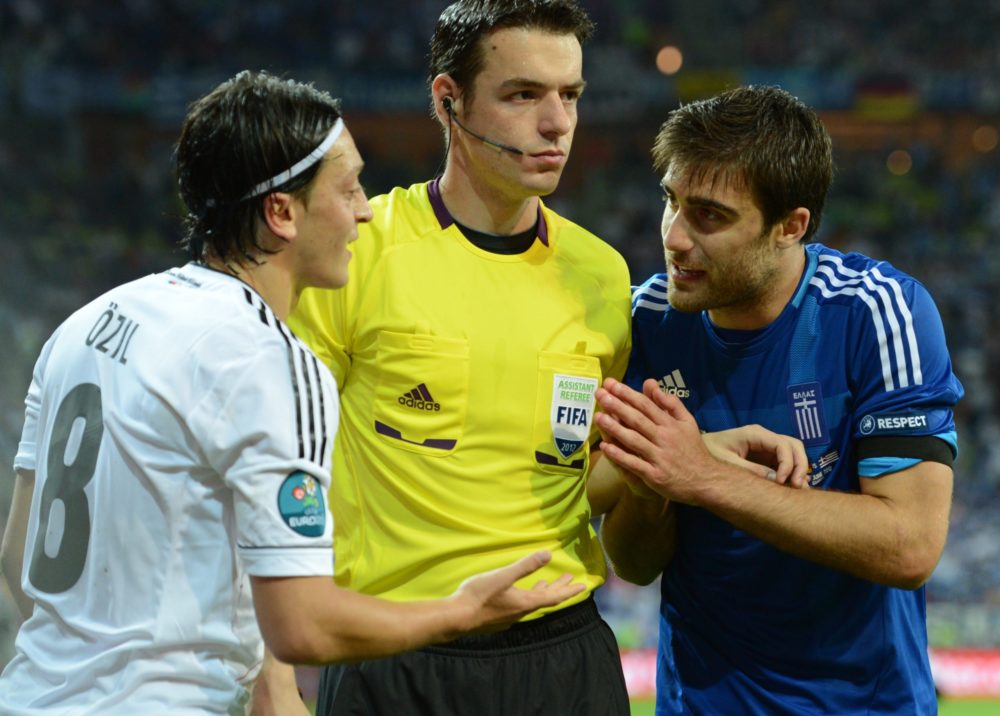 Greek defender Sokratis Papastathopoulos (R) argues with German midfielder Mesut Oezil during the Euro 2012 football championships quarter-final match Germany vs Greece on June 22, 2012 at the Gdansk Arena. Germany won 4 to 2. AFP PHOTO / CHRISTOF STACHE