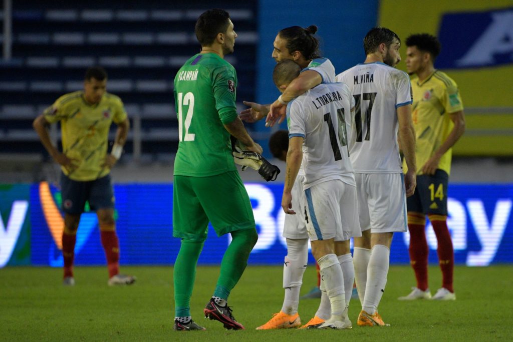 Uruguay's goalkeeper Martin Campana (L), Lucas Torreira (L) and Martin Caceres celebrates after defeating Colombia 3-0 in their closed-door 2022 FIFA World Cup South American qualifier football match at the Metropolitan Stadium in Barranquilla, Colombia, on November 13, 2020.(Photo by RAUL ARBOLEDA/AFP via Getty Images)