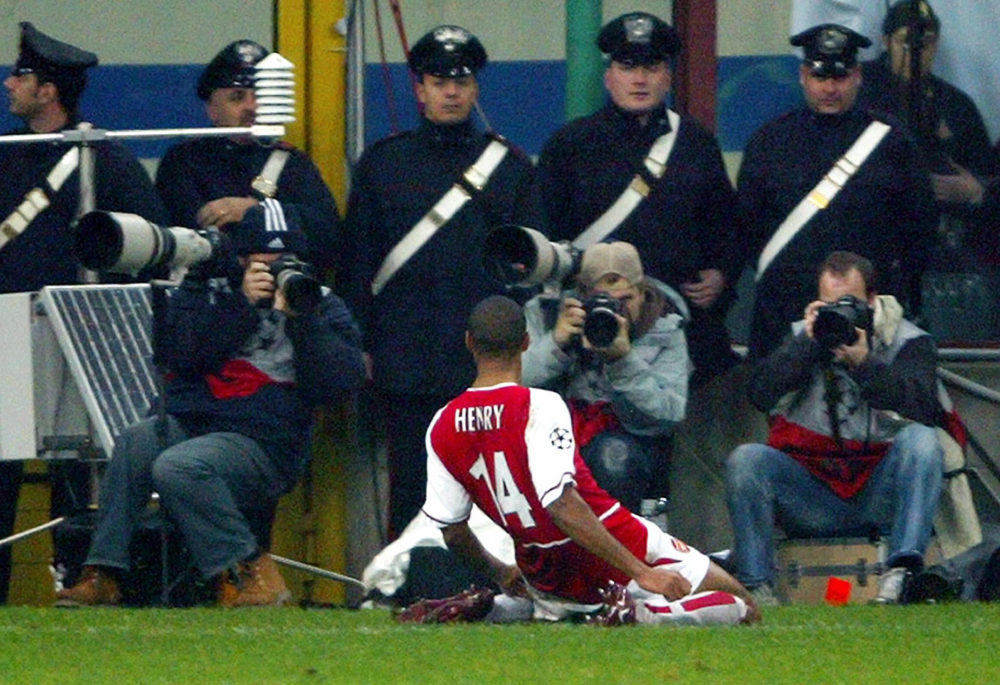 MILAN, ITALY: Arsenal's French striker Thierry Henry celebrates in front of photographers and Italian Carabinieri after scoring against Inter Milan during their Champions league group B match at Milan's San Siro stadium 25 November 2003. Arsenal won the match 5-1. AFP PHOTO PAOLO COCCO (Photo credit should read PAOLO COCCO/AFP via Getty Images)