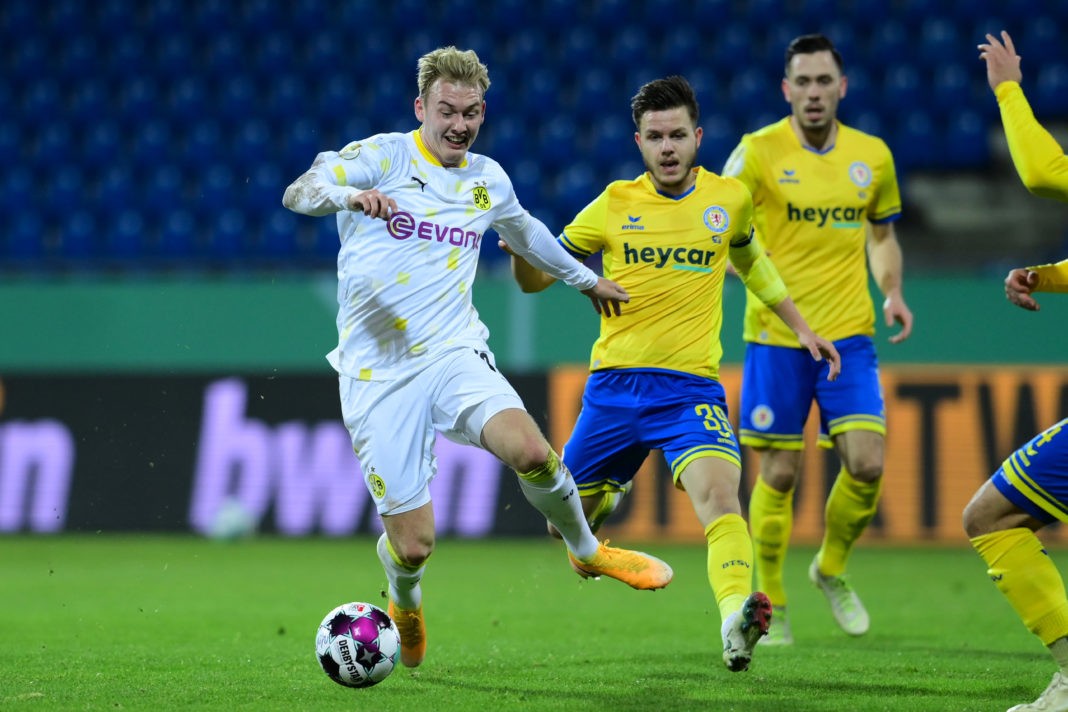 BRAUNSCHWEIG, GERMANY: Julian Brandt (L) of Borussia Dortmund competes for the ball with Patrick Kammerbauer (R) of Eintracht Braunschweig during the DFB Cup second round match between Eintracht Braunschweig and Borussia Dortmund at Eintracht-Stadion on December 22, 2020. (Photo by Oliver Hardt/Getty Images)