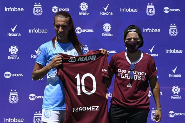 Argentine transgender footballer Mara Gomez (L) of Villa San Carlos poses with a jersey of Lanus with her name on it given as present after an Argentina first division female football match against Between Villa San Carlos and Lanus at Genacio Salice stadium in Berisso, Buenos Aires, Argentina on December 7, 2020. - Gomez is the first transgender footballer to play in the first division of the Argentine female league. (Photo by JUAN MABROMATA / AFP)