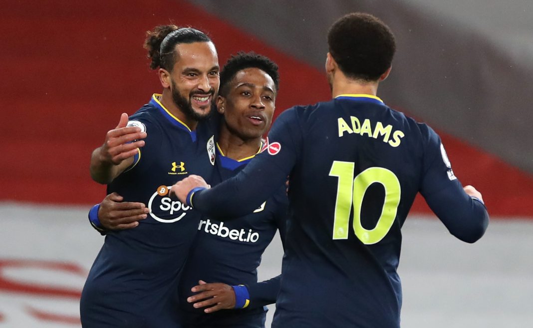 Southampton's English midfielder Theo Walcott (L) celebrates scoring the opening goal with Southampton's English defender Kyle Walker-Peters (C) and Southampton's English midfielder Che Adams during the English Premier League football match between Arsenal and Southampton at the Emirates Stadium in London on December 16, 2020. (Photo by PETER CZIBORRA / POOL / AFP)