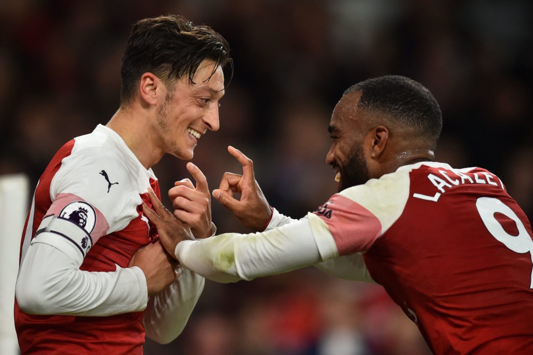 Arsenal's German midfielder Mesut Ozil (L) celebrates with Arsenal's French striker Alexandre Lacazette after scoring their first goal during the English Premier League football match between Arsenal and Leicester City at the Emirates Stadium in London on October 22, 2018. (Photo by Glyn KIRK / IKIMAGES / AFP)