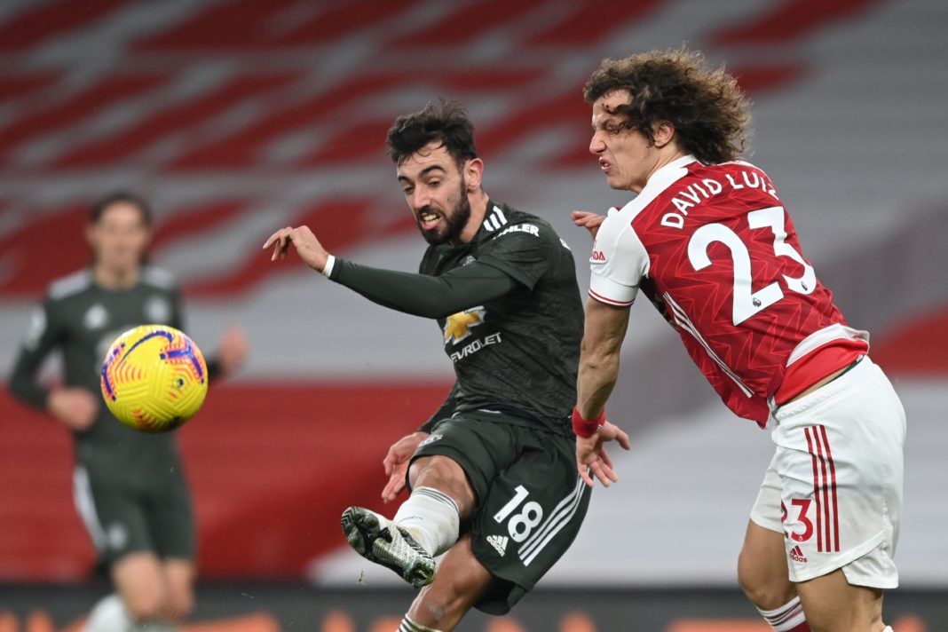 Manchester United's Portuguese midfielder Bruno Fernandes (L) gets his shot away past Arsenal's Brazilian defender David Luiz (R) but misses the target during the English Premier League football match between Arsenal and Manchester United at the Emirates Stadium in London on January 30, 2021. (Photo by Shaun Botterill / POOL / AFP)