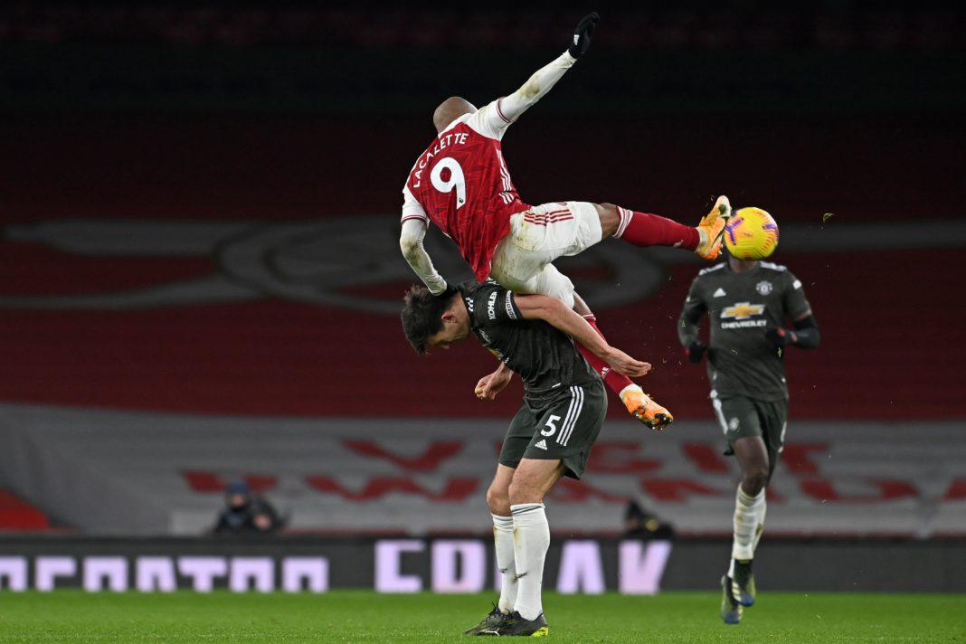 Manchester United's English defender Harry Maguire vies with Arsenal's French striker Alexandre Lacazette (up) during the English Premier League football match between Arsenal and Manchester United at the Emirates Stadium in London on January 30, 2021. (Photo by Andy Rain / POOL / AFP)