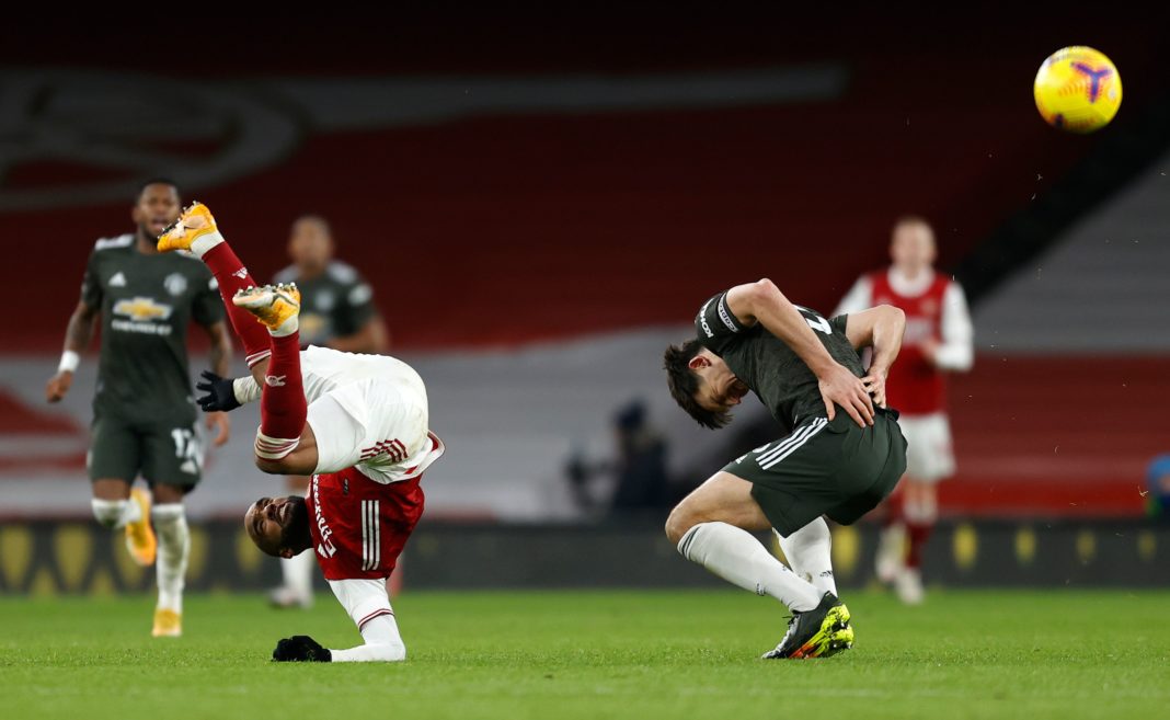 Arsenal's French striker Alexandre Lacazette (L) clashes with Manchester United's English defender Harry Maguire during the English Premier League football match between Arsenal and Manchester United at the Emirates Stadium in London on January 30, 2021. (Photo by Ian KINGTON / IKIMAGES / AFP)