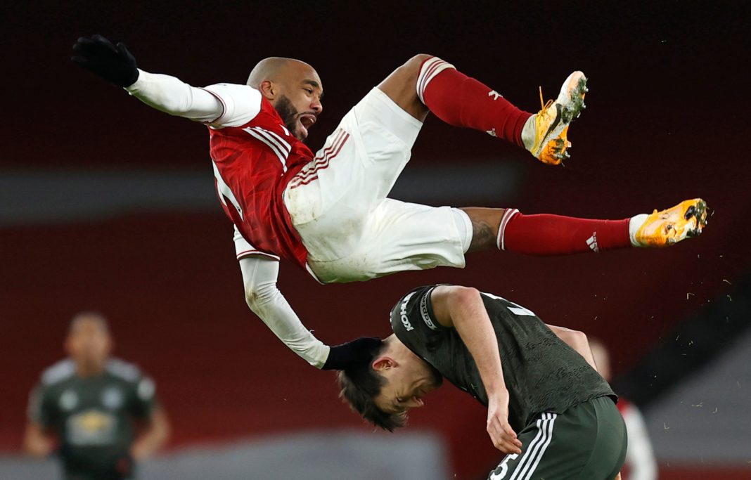 Arsenal's French striker Alexandre Lacazette (top) clashes with Manchester United's English defender Harry Maguire during the English Premier League football match between Arsenal and Manchester United at the Emirates Stadium in London on January 30, 2021. (Photo by Ian KINGTON / IKIMAGES / AFP)