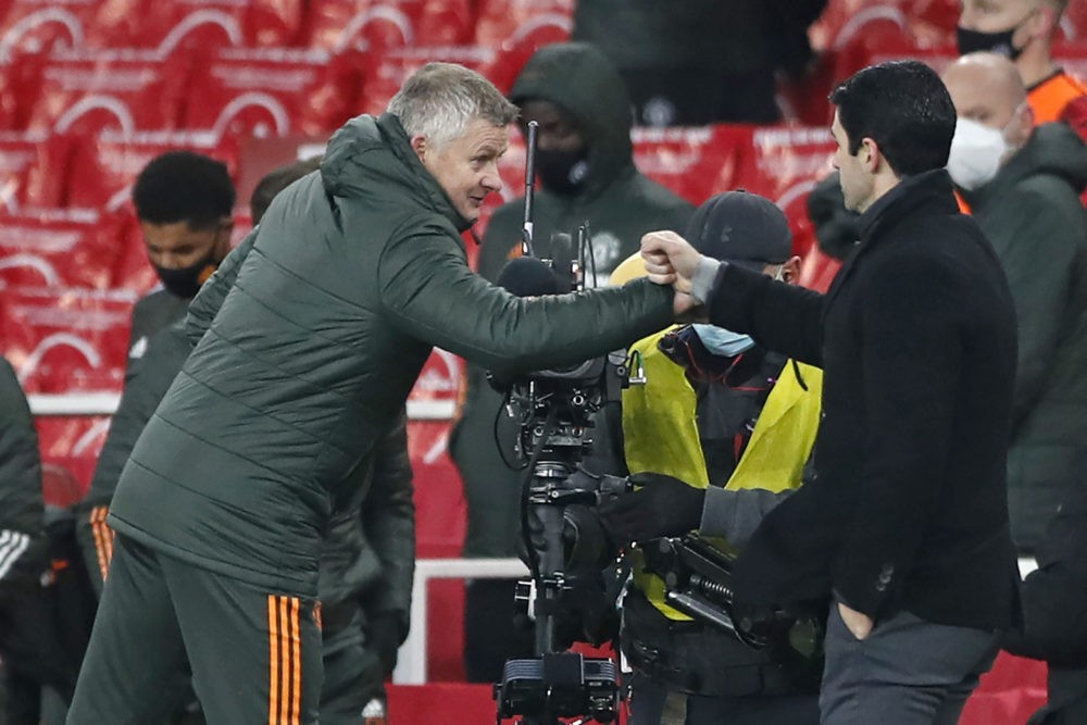 Manchester United's Norwegian manager Ole Gunnar Solskjaer (L) and Arsenal's Spanish manager Mikel Arteta (R) bump fists after the English Premier League football match between Arsenal and Manchester United at the Emirates Stadium in London on January 30, 2021. - The game finished 0-0. (Photo by Alastair Grant / POOL / AFP) / RESTRICTED